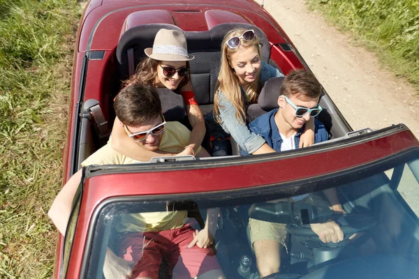 Amigos felizes dirigindo em carro cabriolet no país — Fotografia de Stock