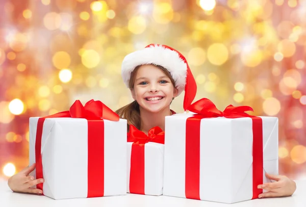 Leende flicka i Tomtemössa med julklappar — Stockfoto
