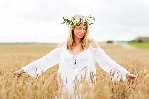Glad ung kvinna i blomma krans på spannmål fält — Stockfoto
