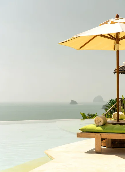Uitzicht vanaf infinity rand zwembad met parasol naar zee — Stockfoto