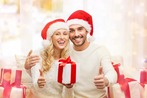 Gelukkige paar met de giften van Kerstmis en duimschroef opwaarts — Stockfoto