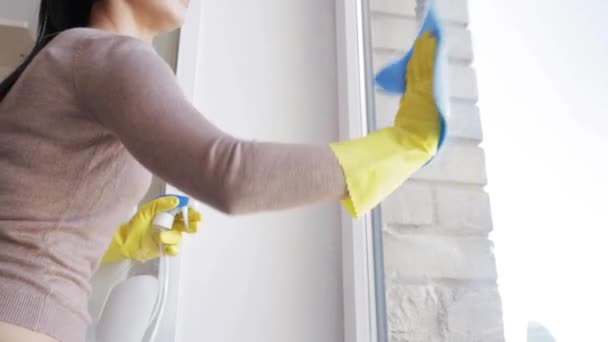 Kvinna i handskar rengöring fönster med trasa — Stockvideo