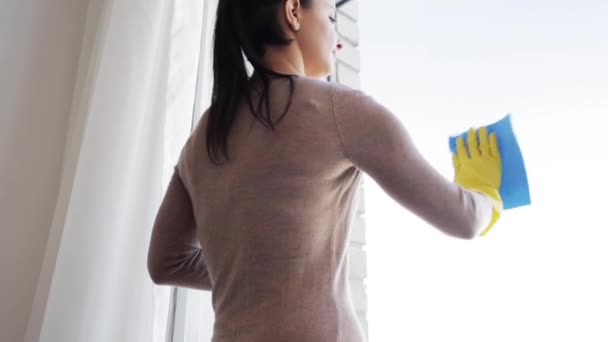 Kvinna i handskar rengöring fönster med trasa — Stockvideo