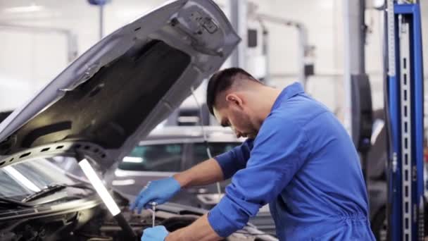 Механик с гаечным ключом ремонта автомобиля в мастерской — стоковое видео