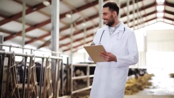 Veterinário com vacas em galpão na fazenda leiteira — Vídeo de Stock