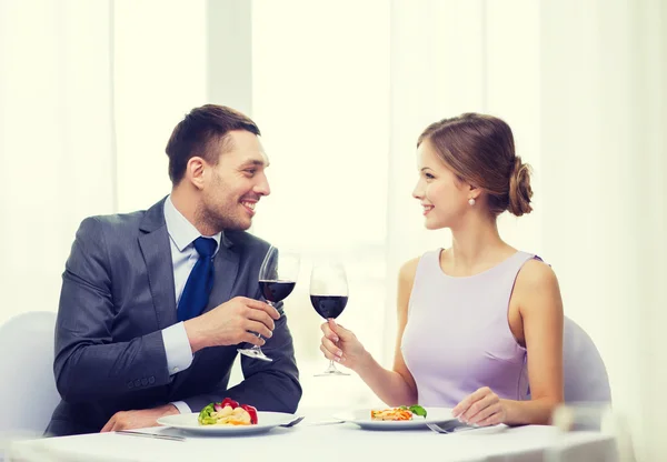 Casal com prato principal e vinho tinto no restaurante — Fotografia de Stock