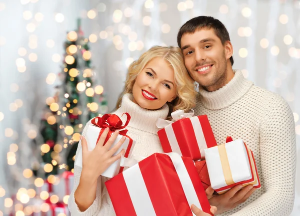 Lyckliga paret i tröjor håller julklappar — Stockfoto