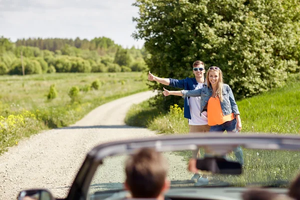 Casal carona e parar de carro no campo — Fotografia de Stock