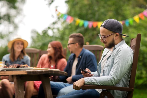 Uomo con smartphone e amici alla festa estiva — Foto Stock