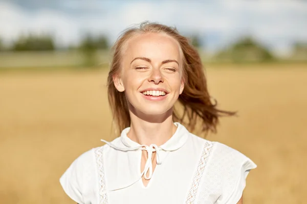 Lachende jonge vrouw in wit op granen veld — Stockfoto