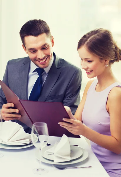Couple souriant avec menu au restaurant — Photo