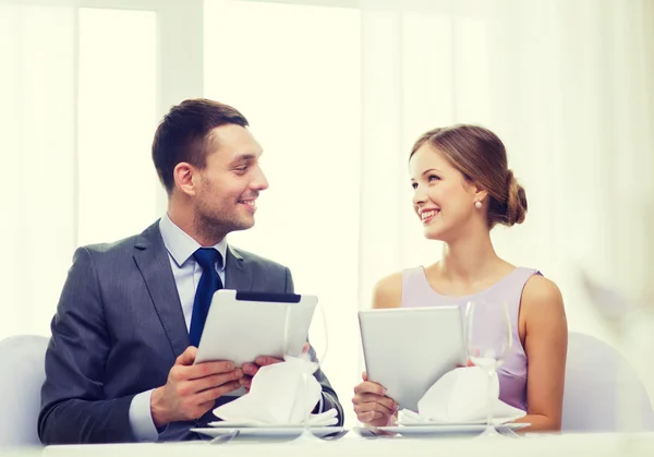 Casal com menus no tablet pc no restaurante — Fotografia de Stock