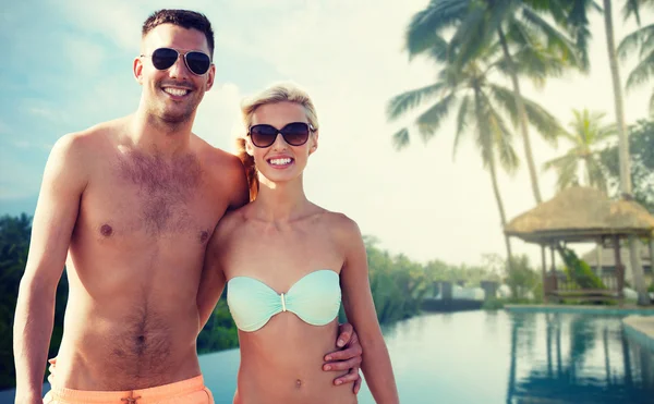 Happy couple in swimwear hugging over hotel resort — Stock Photo, Image