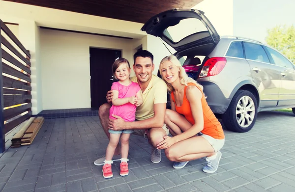 Família feliz com carro hatchback em casa estacionamento — Fotografia de Stock