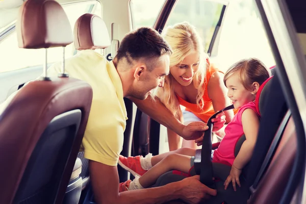Glückliche Eltern schnallen Kind mit Autogurt an — Stockfoto