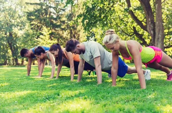 Grupo de amigos o deportistas que hacen ejercicio al aire libre —  Fotos de Stock