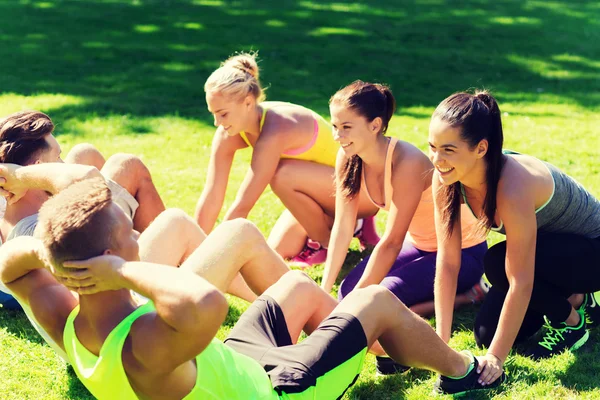 Grupo de amigos o deportistas que hacen ejercicio al aire libre — Foto de Stock