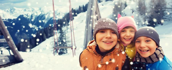 Crianças felizes abraçando sobre fundo de inverno — Fotografia de Stock