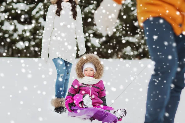 Família feliz com trenó andando na floresta de inverno — Fotografia de Stock