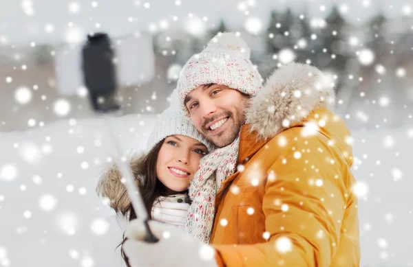 Feliz pareja tomando selfie por teléfono inteligente en invierno —  Fotos de Stock