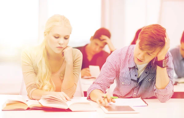 Müde Schüler mit Tablet-PC, Büchern und Notizbüchern — Stockfoto