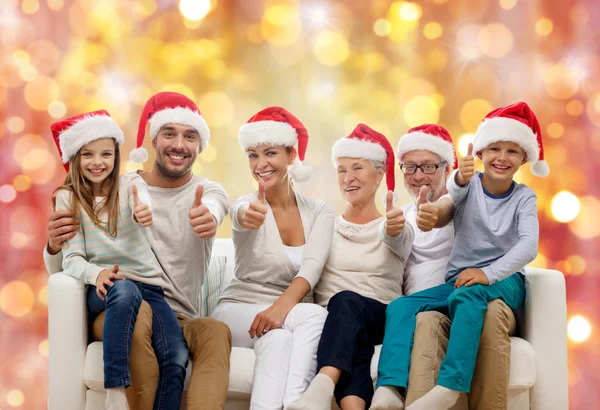 幸福的家庭，在圣诞老人的帽子现身竖起大拇指 — 图库照片
