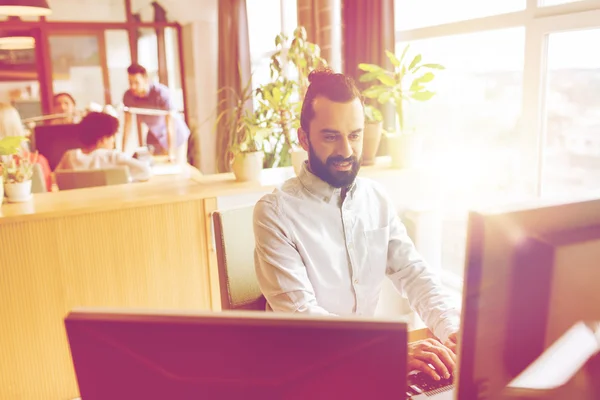 Lyckliga kreativa manliga kontorist med dator — Stockfoto