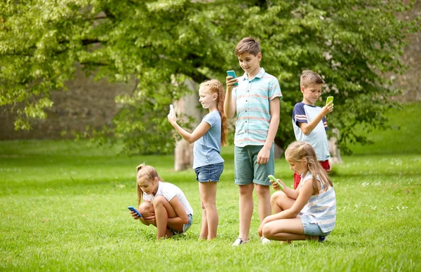 아이 들 여름 공원에서 게임 스마트폰 — 스톡 사진