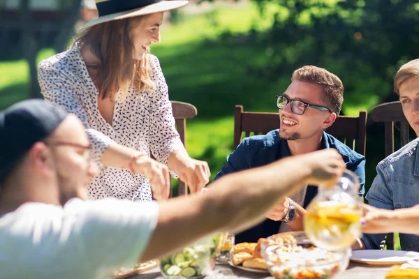 快乐的朋友吃晚饭在夏天花园聚会 — 图库照片