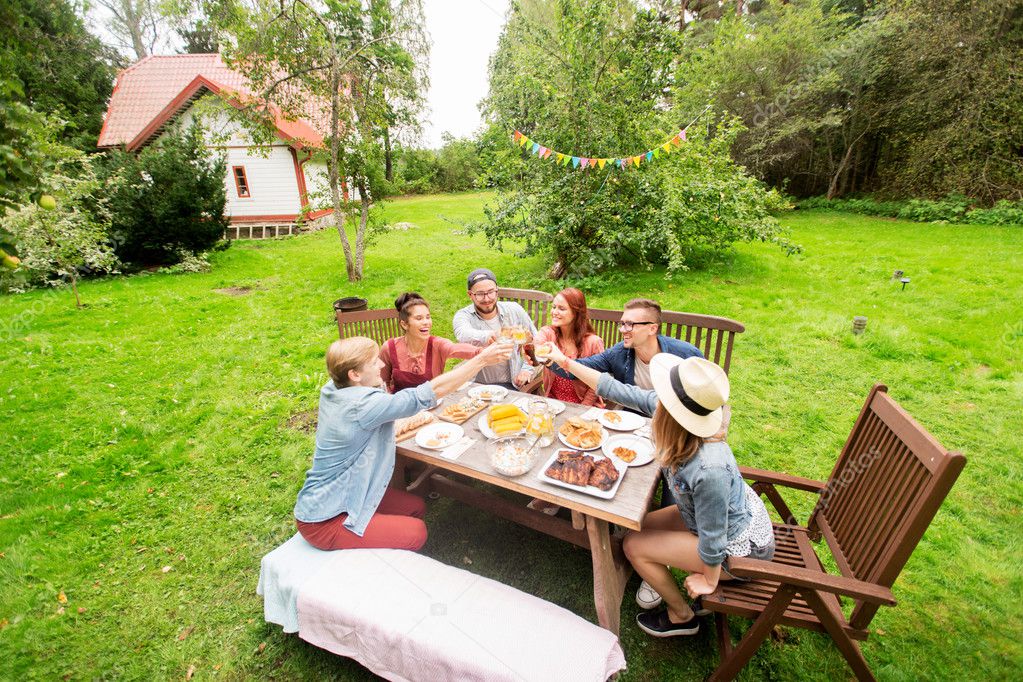 Glückliche Freunde beim Abendessen bei sommerlicher