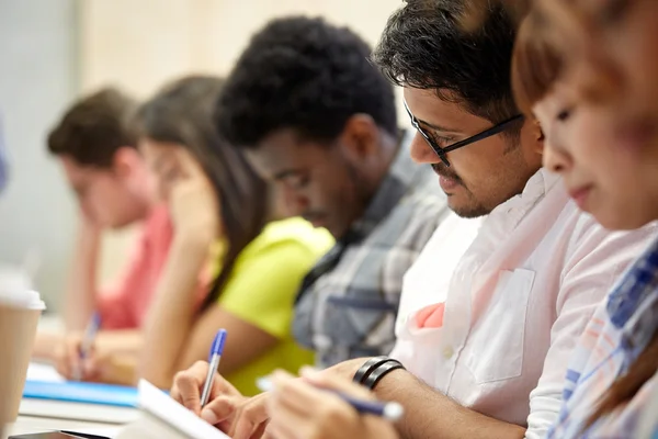 Group of international students writing at lecture — Stock Photo, Image