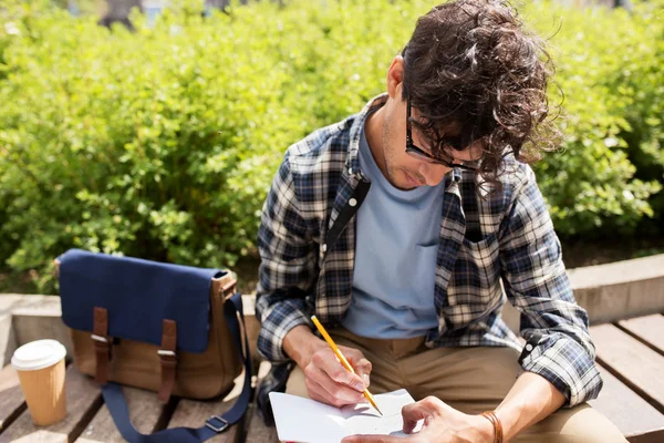 Man with notebook or diary writing on city street — Stock Photo, Image