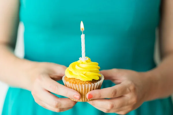 Žena s hořící svíčkou na narozeniny cupcake — Stock fotografie