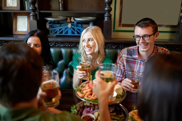 Přátelé stolování a pití piva v restauraci — Stock fotografie