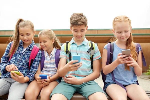 Elementary school students with smartphones — Stock Photo, Image