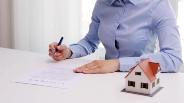 女人用房子模型和钢笔签署合同 — 图库视频影像