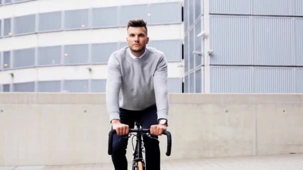Fiatal férfi kerékpározik a város utcáján — Stock videók