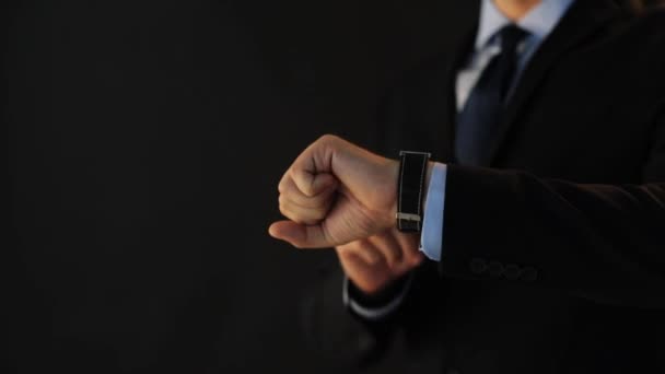 Hombre de negocios señalando el reloj inteligente en su mano — Vídeos de Stock