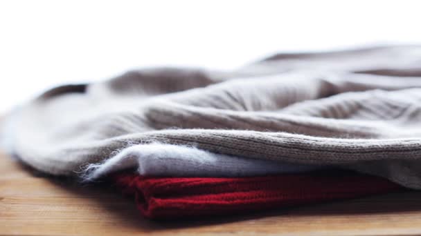 Prendas de punto o ropas de lana sobre mesa de madera en casa — Vídeo de stock