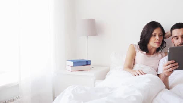 Smiling couple in bed with tablet pc computer — Stock Video