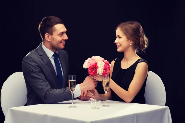 Homem sorrindo dando buquê de flores para a mulher — Fotografia de Stock