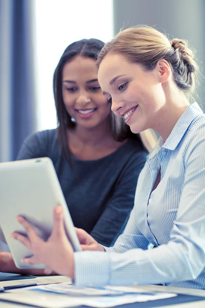 Mulheres de negócios sorridentes com tablet pc no escritório — Fotografia de Stock