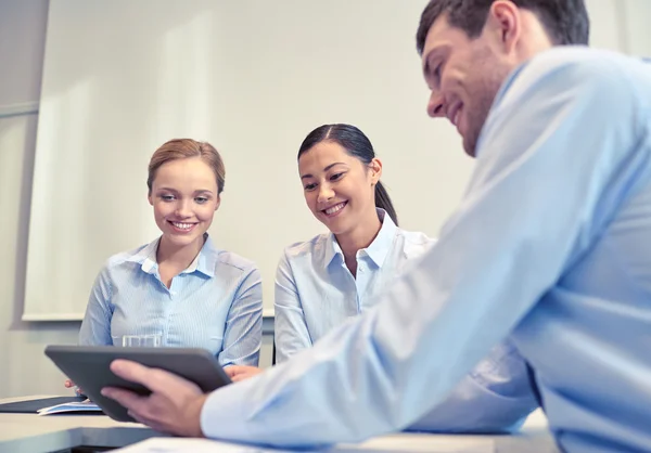 Smiling businesspeople with tablet pc in office — Stock Photo, Image