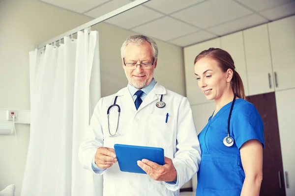 Senior doctor and nurse with tablet pc at hospital — Stock Photo, Image