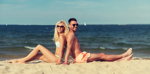 Yaz plaj üzerinde oturan mayo mutlu çift — Stok fotoğraf