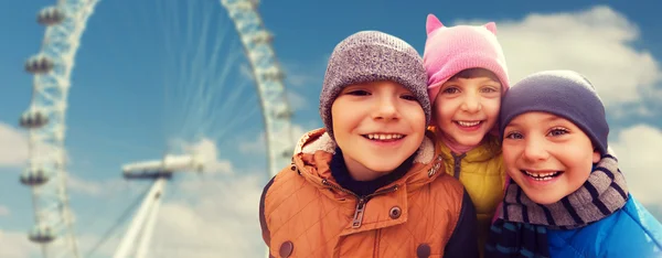 Happy little children faces over ferry wheel — Stockfoto