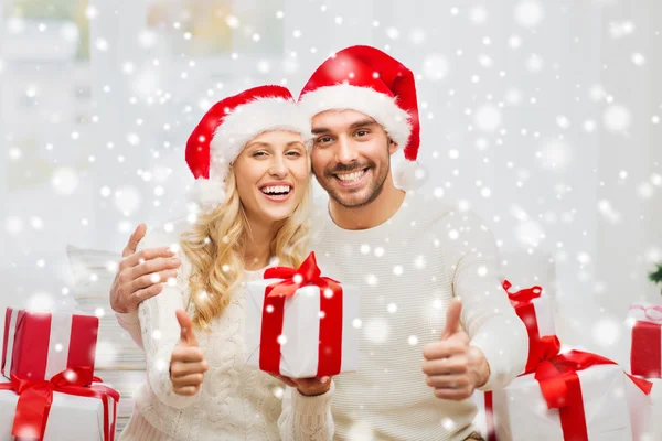 Casal feliz com presentes de Natal e polegares para cima — Fotografia de Stock