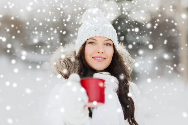 Heureuse jeune femme avec tasse de thé en plein air en hiver — Photo