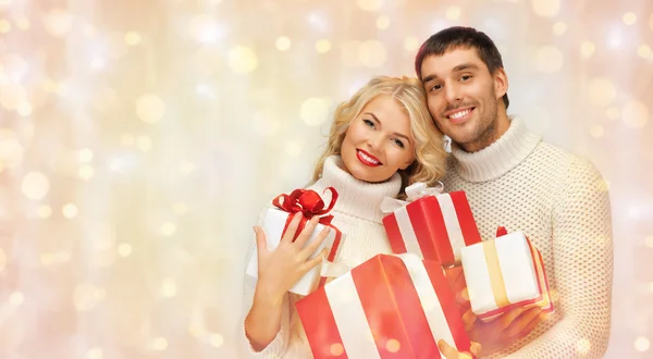 Casal feliz em camisolas segurando presentes de Natal — Fotografia de Stock