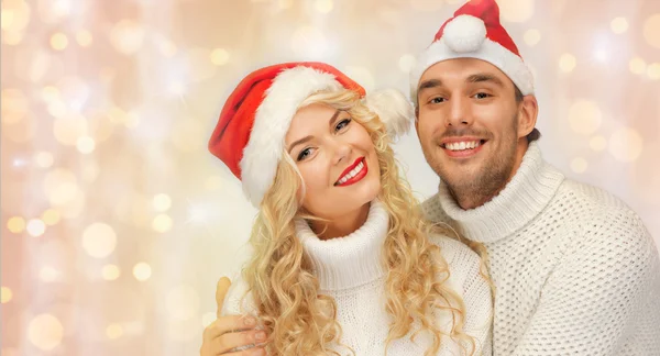 Casal feliz família em camisolas e chapéus de santa — Fotografia de Stock